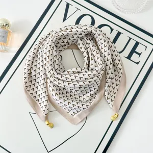 Elegant geometric pattern square scarf with chic gold metal pendants for women's stylish wear.