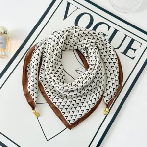 Chic geometric print square scarf with brown border and gold pendants for women styling.