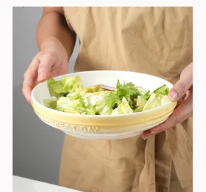 Ceramic salad plate detail view, minimalist yellow gradient design with embossed text.