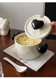Detailed view of a cute ceramic instant noodle bowl with black heart handles and lid.