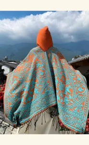 Ethnic style hooded poncho cape for women, vibrant orange with blue floral pattern tassels.