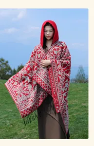 Ethnic style hooded poncho detail showing intricate red and grey woven pattern and fringe hem.