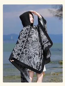 Stylish women's hooded knitted cape shawl, classic black and white pattern for cozy autumn wear.