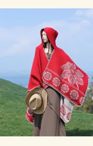 Detail shot of a red hooded ethnic floral cape, cozy warm wool-blend shawl for women.