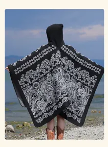 Detailed back view of the stylish black and white patterned knitted hooded cape shawl.