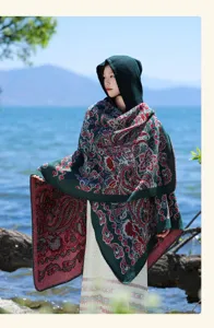 Detail view of the elegant dark green hooded cape with vintage red paisley pattern for women.