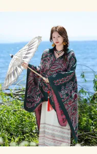 Details of the vintage ethnic knit shawl cape featuring intricate paisley patterns and tassels.