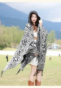 Detailed view of women black white hooded ethnic poncho, tassel fringe knit cape, cozy.