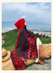Bohemian hooded cloak detail showing colorful geometric patterns and cozy fabric texture outdoors.