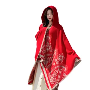 Ethnic style red hooded knitted cape with exquisite paisley floral patterns and white trim.