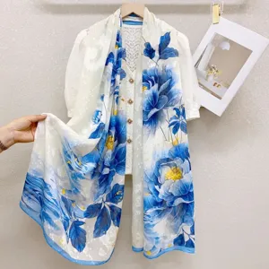 Detailed view of the elegant blue and white floral silk scarf with draped fabric.