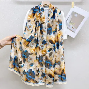 Detailed view of lightweight floral silk scarf with elegant blue and yellow vintage botanical print.