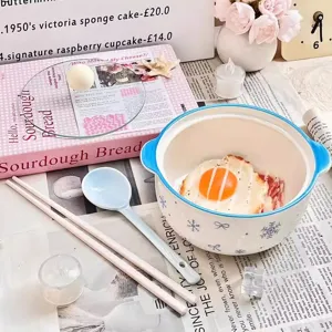 Ceramic noodle bowl detail featuring cute snowflake pattern, matching spoon and chopsticks setup.