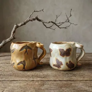 Handgemachte Keramik Kaffeetasse im Vintage Stil mit kunstvollen Schmetterling und Vogel Motiven.