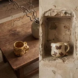 Rustikale handgemachte Keramik Kaffeetasse Detail, künstlerisches Schmetterlingmuster.
