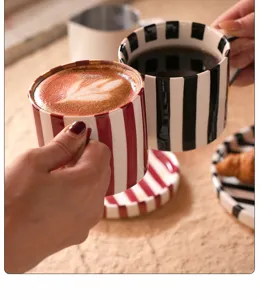 Conjunto de taza y plato de café de cerámica a rayas retro, detalle lifestyle pintado.