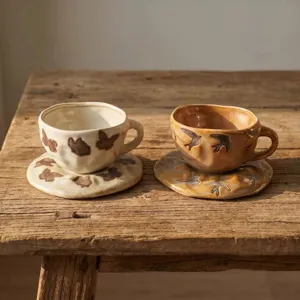 Taza de café de cerámica artesanal con platillo en mesa de madera rústica, detalle.