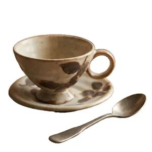 Set di tazza da caffè e piattino in ceramica vintage con motivo a foglia e cucchiaio.