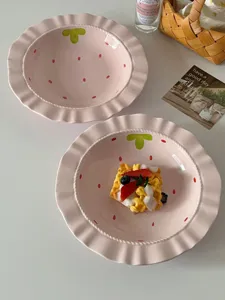 Pink ceramic strawberry plate detail, cute straw hat design with ruffled rim for table decor.