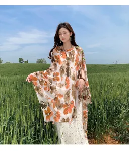 Outdoor detail view of Chinese style floral print silk shawl with delicate tassel hem and classic knot buttons.