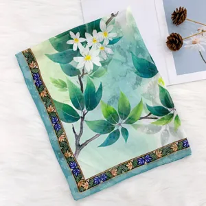 Green floral silk scarf detail featuring elegant Chinese style prints and a decorative border.