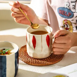 Tasse à café en céramique créative japonaise avec cuillère dorée et sous-verre bureau.