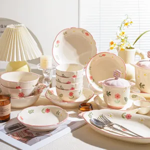 Set di stoviglie in ceramica con motivo floreale rosa, ciotole e piatti eleganti.