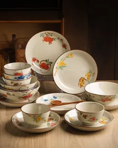 Close-up detail of Japanese underglaze ceramic tableware set showing hand-painted fruit design.