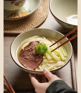 Detailed shot of ceramic noodle bowl showcasing underglaze Japanese pattern and practical use.