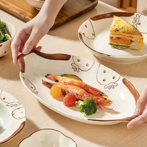 Joli service de vaisselle en céramique avec motifs de fraises brunes peints à la main.