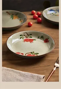 Detail shot of vintage Japanese style ceramic deep plate with hand-painted pomegranate design.