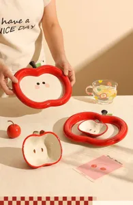 Vue détaillée ensemble assiette céramique pomme mignonne, émail rouge vif, présentation de table.