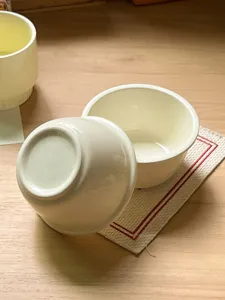 Close-up detail of the minimalist ceramic bowl, showcasing smooth glaze and table setting.