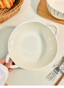 Detailed close-up of white ceramic double-handled soup bowl, home tableware use.