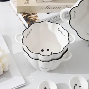 Ceramic pumpkin soup bowl detail shot featuring cute smiley face design and double handle.
