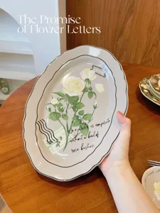 Vue détaillée d'une assiette ovale en céramique vintage avec motif de roses jaunes.