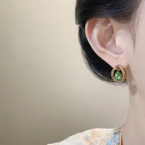 Nahaufnahme Detail von edlem tropfenförmigen Kristall Ohrring am Ohr, elegantes Design.
