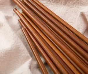 Wooden chopsticks detail view, natural solid wood texture close-up for kitchen use.