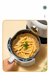Detailaufnahme von Heißluftfritteuse Backpapier Einlagen mit leckeren Pommes frites bereit.