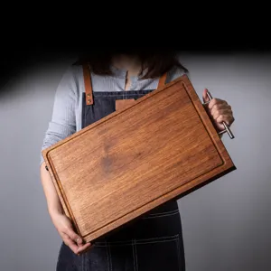 Massief houten snijplank met metalen handvat, zeer robuust voor dagelijks gebruik.