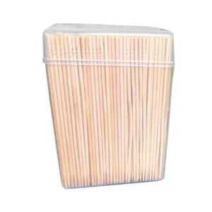 Disposable wooden toothpicks long fruit skewers in clear plastic box for kitchen use.