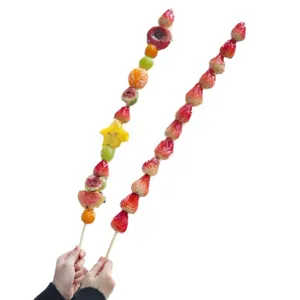 Traditional long fruit candy skewers sugar coated fresh strawberries mix fruits display