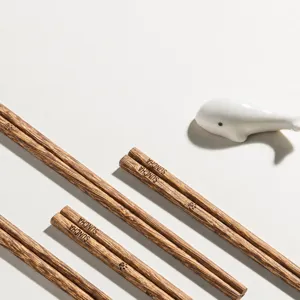 Wooden children chopsticks set with cute ceramic whale rest for home dining use daily.