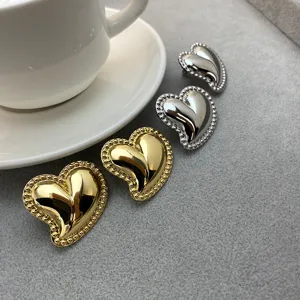 Détail en gros plan des superbes boucles d'oreilles cœur en métal finition or et argent.