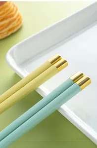 Bacchette in lega colorata con punte dorate, stoviglie resistenti per uso domestico.