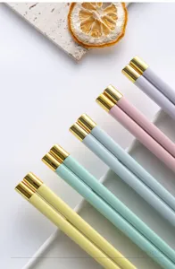 Vista dettagliata di bacchette in lega colorata macaron con punte dorate, resistente.