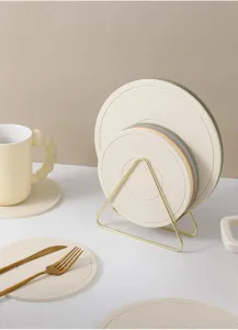 Detailed view of silicone heat insulation mats and gold metal storage rack on clean tabletop.