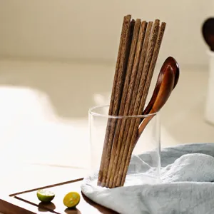 Natural ironwood chopsticks set with wooden spoon in glass cup kitchen tableware setup.