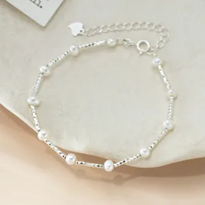Zarte Detailansicht des Silberperlenarmbands mit glitzernden facettierten Perlen und Kette.