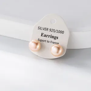 Detailaufnahme eleganter rosa Süßwasserperlen-Ohrstecker auf einer weißen Präsentationskarte.